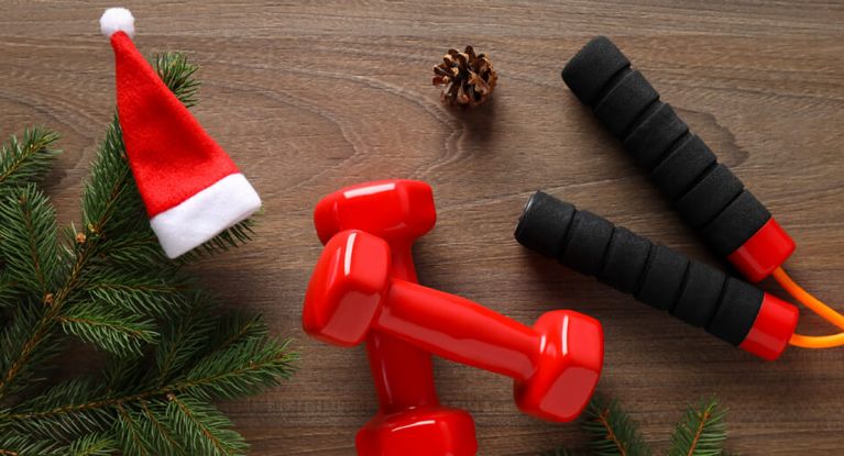 Hanteln und Springseile liegen neben einer Nikolausmütze und Tannenzweigen