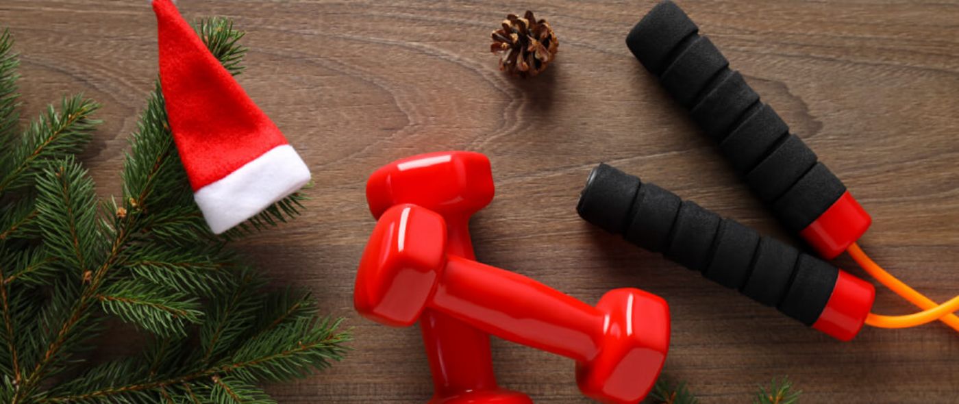 Hanteln und Springseile liegen neben einer Nikolausmütze und Tannenzweigen