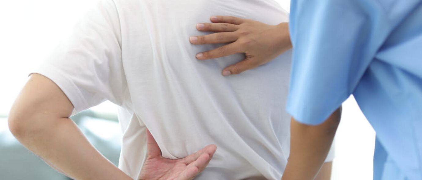 Arzt prüft den Rücken eines Patienten