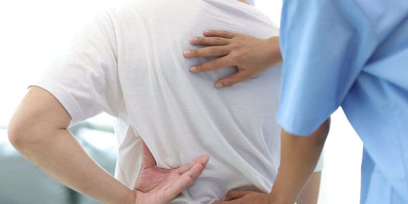 Arzt prüft den Rücken eines Patienten