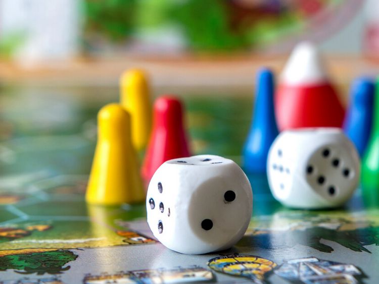 Würfel und Spielfiguren auf einem Spielbrett